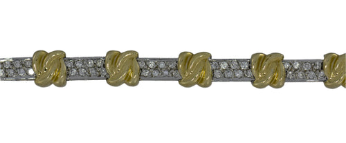 Bracelet with gold floral designs and clear stones on a gray background