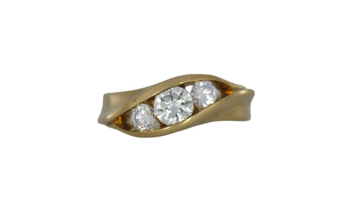 Gold ring with three diamonds on a white background