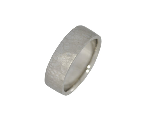 Silver ring with a textured band on a white background